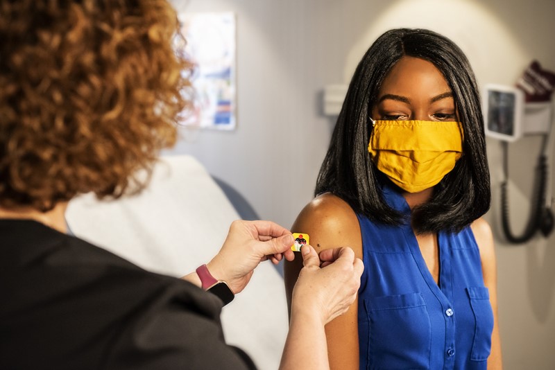 Black woman being vaccinated