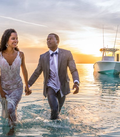 Couple in The Bahamas coming out of the water in their suits
