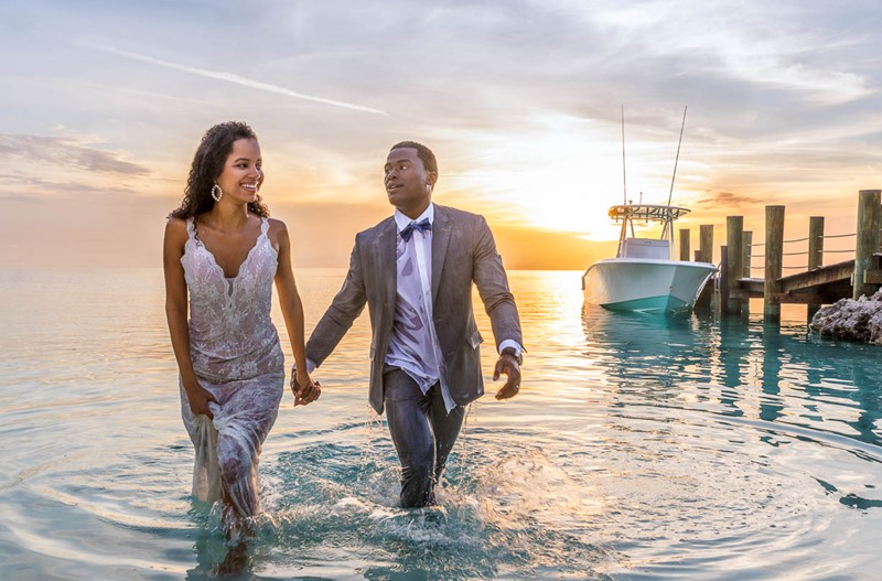 Couple in The Bahamas coming out of the water in their suits